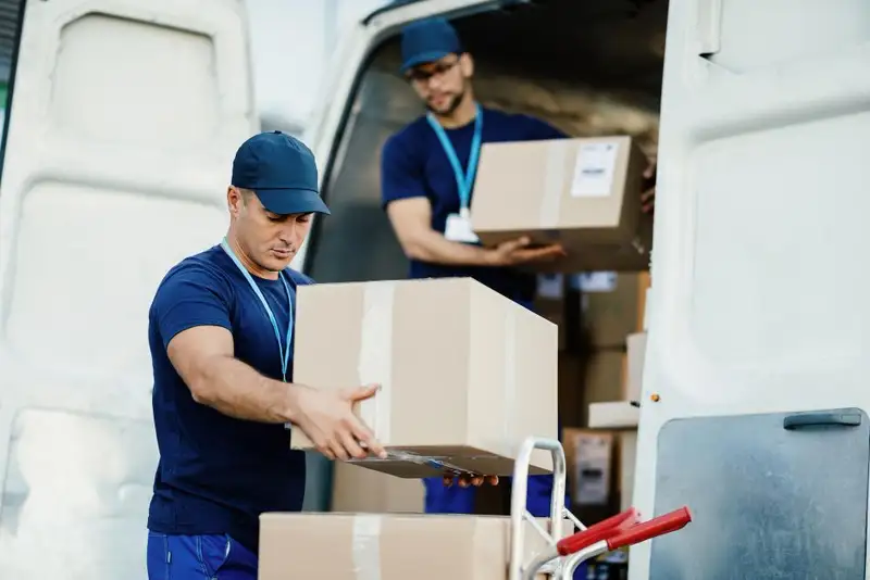 Movers unloading boxes from a van